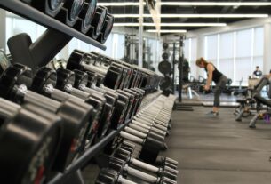 woman standing surrounded by exercise equipment